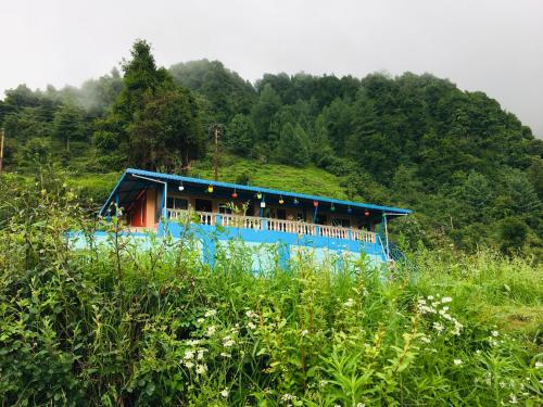 a blue bus parked in front of a building at LaCliff Nature Home in Dhanaulti