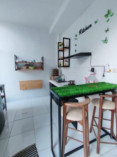 a kitchen with a green counter and stools at Rumah Kembar DI kawasan wisata lembang in Citeureup 1