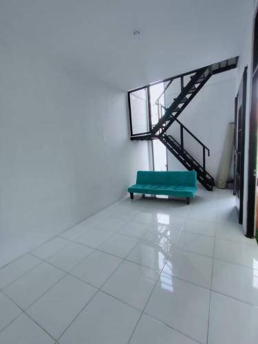 a green bench in a room with a staircase at Rumah Kembar DI kawasan wisata lembang in Citeureup 1