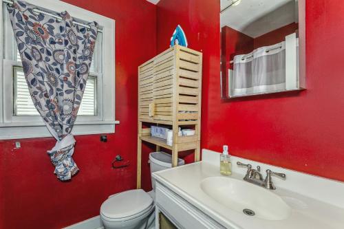 a red bathroom with a toilet and a sink at RENU at ICT St Claire House in Wichita