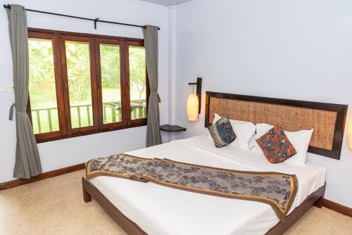 um quarto com uma cama grande e uma janela em Satva Samui Yoga and Wellness Resort em Nathon Bay