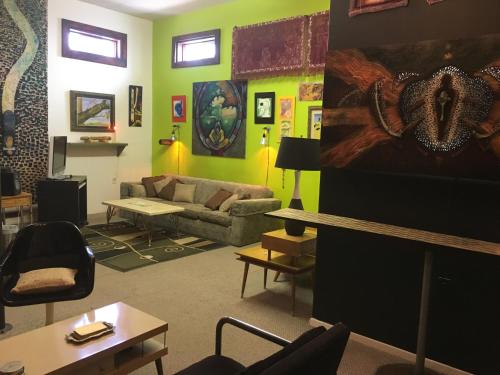 a living room with a couch and a table at SPACE CASTLE: a 1950s Gas Station transformed into an Art Themed Wonderland in Truth or Consequences