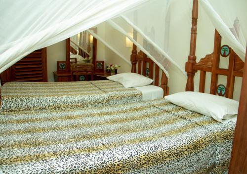 Tembo Court Apartments(Ocean Beach) في ماليندي: غرفة نوم بسريرين ودرج