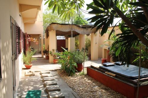 un patio de un edificio con plantas y un colchón en La Guesthouse Étoile, en Cotonou