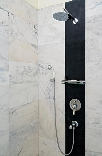 a shower with a shower head in a bathroom at Sariska Manor Luxury Cottages Tehla in Tehla
