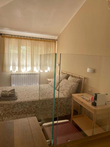 1 dormitorio con cama, mesa y puerta de cristal en Chirone Room, en Mondello