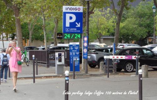 a woman walking down a street next to a parking meter at Hotel Royal Phare in Paris