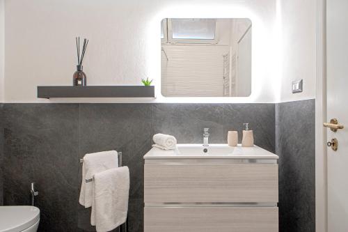 bagno con lavandino e specchio di [FREE PARKING] Appartamento 5 STELLE elegante con suite a Livorno