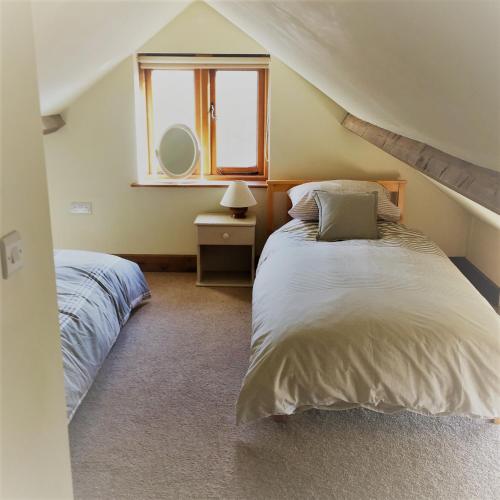 a bedroom with two beds and a window at Meg's Cottage in Taunton