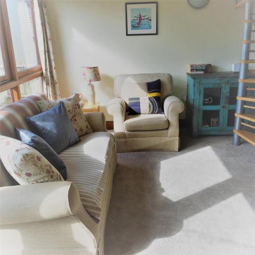 a living room with a couch and two chairs at Meg's Cottage in Taunton