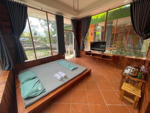 a bedroom with a bed and a tv and windows at Xu xu motel in Bạc Liêu