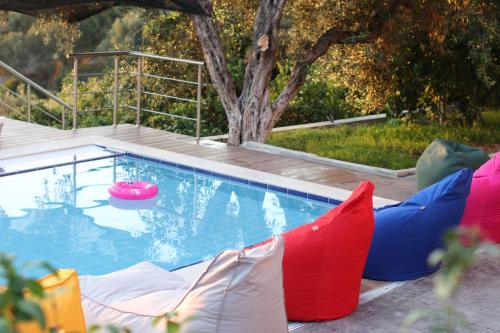 a swimming pool with colorful pillows and a red and blue raft at Vila ELARAD in Vlorë