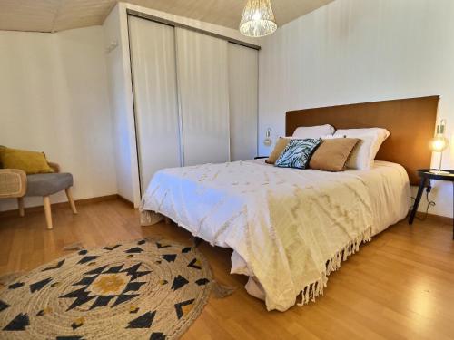 a bedroom with a large bed and a rug at L'abeille - Centre - Parking gratuit in Bourg-de-Péage