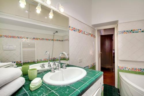baño con lavabo y espejo grande en Stunning Pantheon Apartment, en Roma