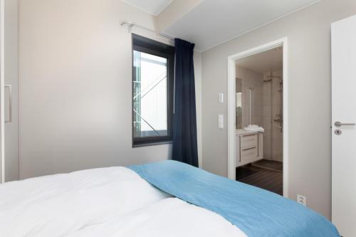 a bedroom with a bed with a window and a bathroom at BJØRVIKA APARTMENTS, Opera Area, Oslo city center in Oslo