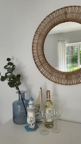 a table with a mirror and glasses and a vase at APARTAMENT przy jeziorze in Borne Sulinowo