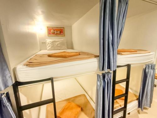 een kleine kamer met een bed en een ladder bij Jomtien Beach Hostel in Jomtien Beach