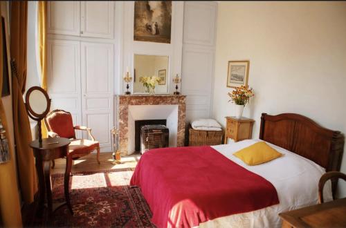 ein Schlafzimmer mit einem Bett mit einer roten Decke und einem Kamin in der Unterkunft Château de Bouillancourt en Sery in Bouillancourt-en-Séry