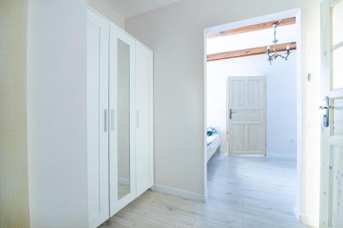 an empty hallway with white walls and a sliding door at SzSM Hadle Szklarskie in Hadle Szklarskie