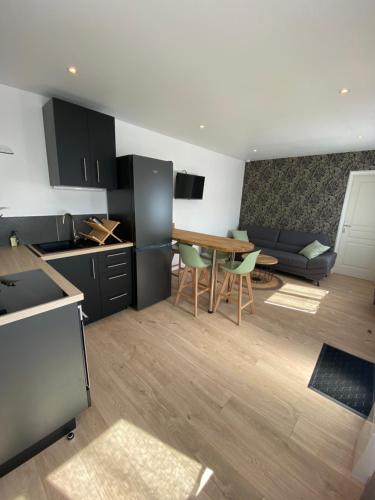 une cuisine et un salon avec une table et un canapé dans l'établissement L’Albâtre - Maison située à quelques pas de la mer, à Saint-Aubin-sur-Scie