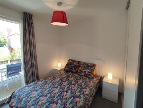ein Schlafzimmer mit einem Bett mit zwei Lampen und einem Fenster in der Unterkunft Douceur du Verdon- Climatisé avec Piscine, Parking in Gréoux-les-Bains