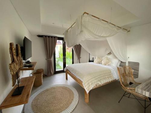 a bedroom with a large bed with a canopy at Villa Kalma Canggu in Canggu