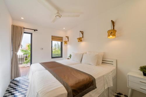 a bedroom with a large bed with a window at Hoi An Wanderlust - Beachside in An Bang