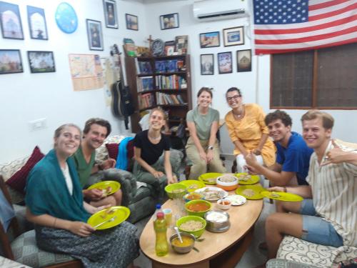 Eine Gruppe von Menschen, die an einem Tisch sitzen und Essen essen. in der Unterkunft Zigzag Homestay in Agra