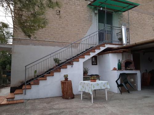 a white building with a staircase and a table at G&M Holiday Home 2 in Minturno