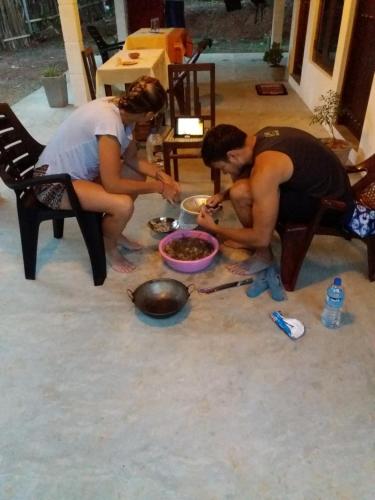 two women and a man eating food on the floor at Cashew Villa Hiriketiya in Hiriketiya