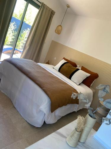a bedroom with a large bed with a large window at Suite La Farigoulette in Marseille