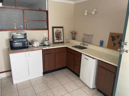 a kitchen with a sink and a microwave at Slow Time Homestay in Auckland