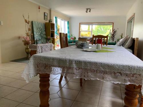 a dining room table with a white table cloth on it at Slow Time Homestay in Auckland