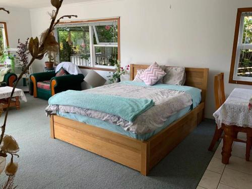 a bedroom with a bed and a couch and a chair at Slow Time Homestay in Auckland