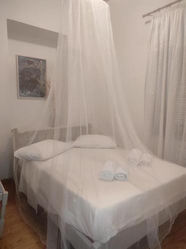 a bedroom with a bed with white mosquito nets at Komfort Stone House in Antimácheia