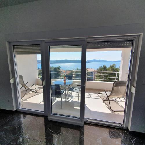 a room with a balcony with a table and chairs at Villa BOTIĆ in Trogir