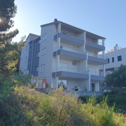 an apartment building on the side of a hill at Villa BOTIĆ in Trogir