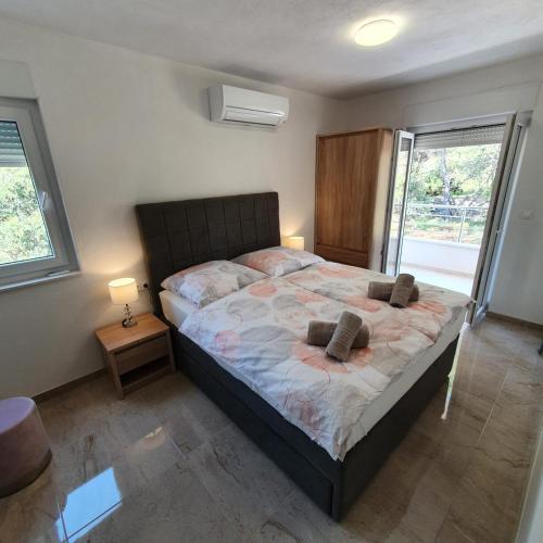 a bedroom with a large bed with two pillows on it at Villa BOTIĆ in Trogir