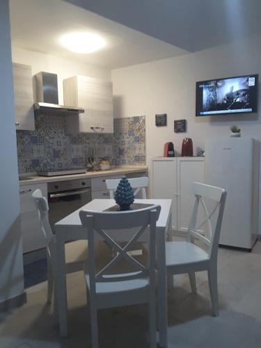 a kitchen with a table and chairs and a kitchen with a tv at A casa dei 3 in Catania