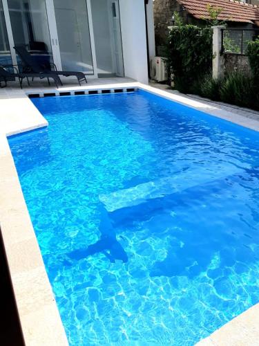 a swimming pool with blue water in a house at Herceg Vila in Trebinje