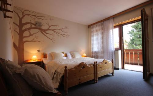a bedroom with a bed with a tree mural on the wall at Residence Ben Ste in Ortisei