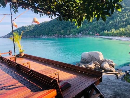 a wooden deck with a view of a body of water at Bambu Huts in Baan Tai