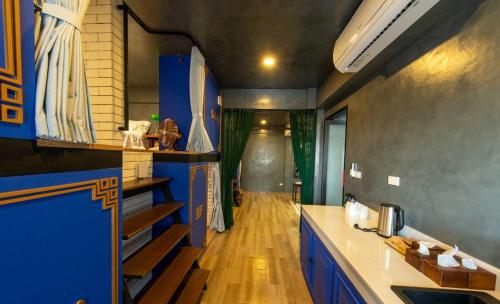 a kitchen with blue cabinets and a wooden floor at Lynlan Hostel & Cafe in Hat Yai