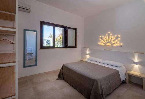a bedroom with a bed and a window and a mirror at Podere Santa Chiara in Otranto