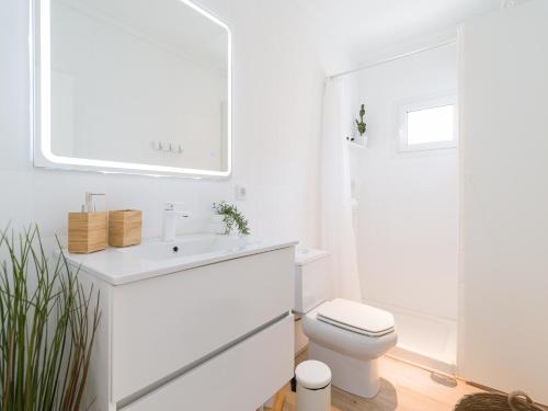 a white bathroom with a toilet and a sink at Viewpoint Over The Cliff By CanariasGetaway in Maspalomas