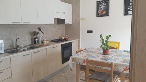 uma cozinha com uma mesa, uma pia e um fogão em CASA GIOVANNI em Polignano a Mare