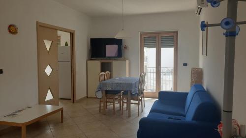 uma sala de estar com um sofá azul e uma mesa em CASA GIOVANNI em Polignano a Mare