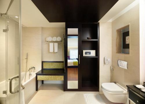 a bathroom with a toilet and a sink and a shower at HYCINTH Hotels in Trivandrum