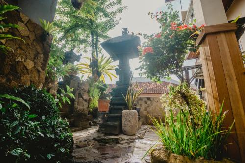 a courtyard with a fountain in a house with plants at Samblung Mas House in Denpasar