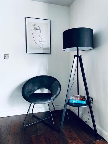a chair and a lamp in a room at 2 Bedroom Penthouse Birmingham in Birmingham